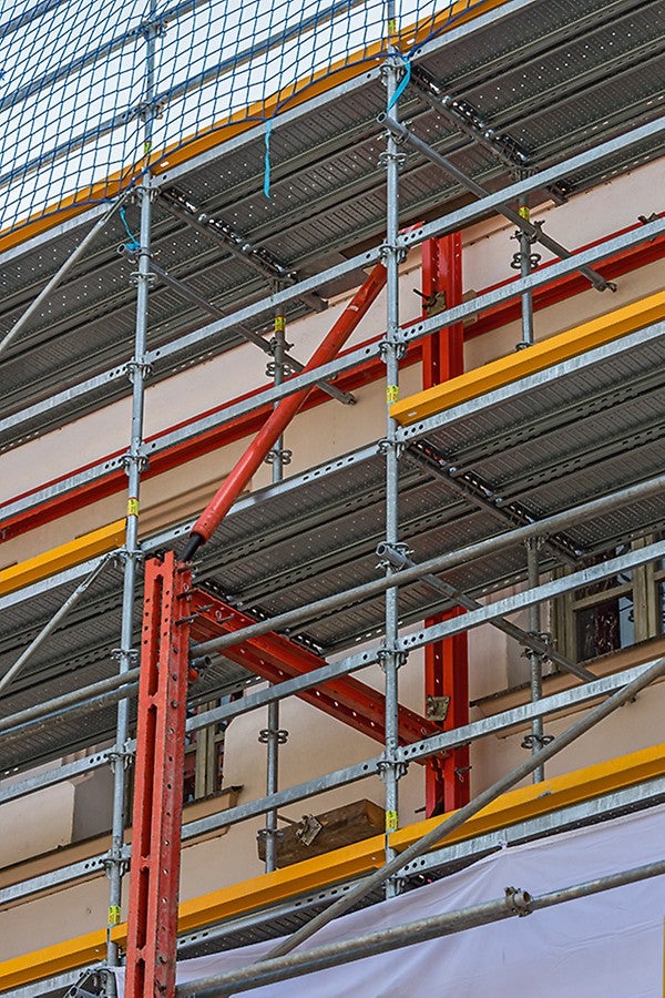 An der bis zu 15 m hohen Hauptfassade übernehmen die roten VARIOKIT Bauteile die Fassadenabstützung und werden durch das PERI UP Fassadengerüst ergänzt. Die Gerüste können sowohl gemeinsam als auch getrennt stehen. So kann das Stützgerüst bereits früher im Bauverlauf entfernt werden, sobald die Abstützung nicht mehr notwendig ist.