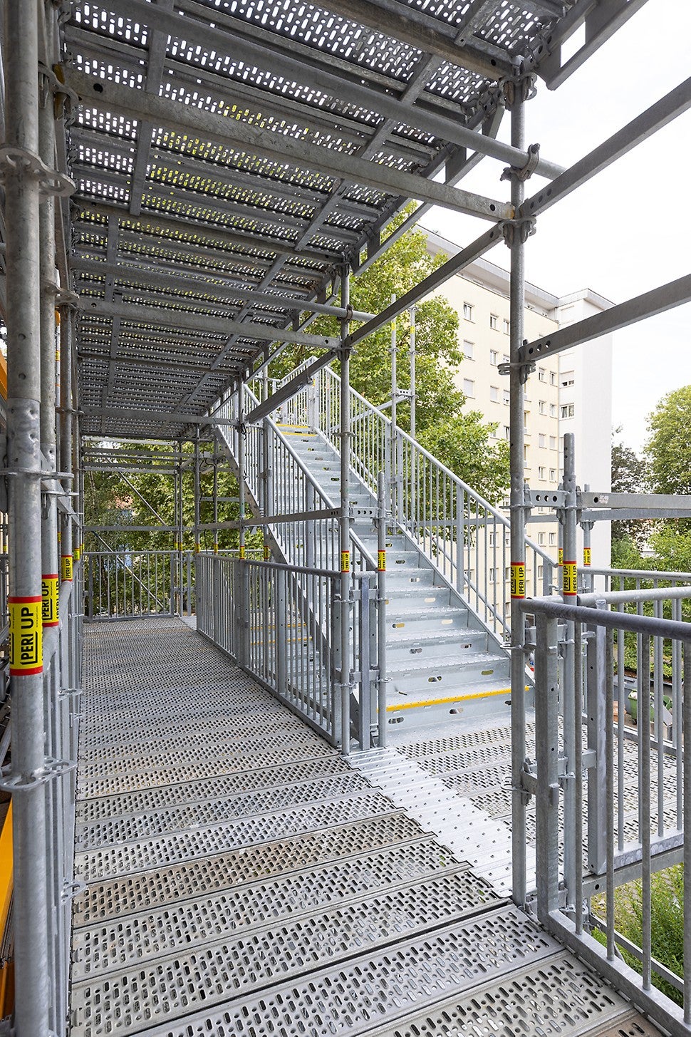 Jeweils zwei hintereinander angebrachte Treppenläufe machen die im Höhenraster von 3,00 m angeordneten Laubengänge zugänglich.