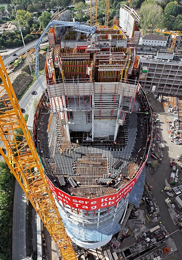 Der Stahlbetonkern des elliptisch geformten Büroturms wächst mithilfe der PERI RCS und ACS Selbstklettertechnik nach oben, die RCS Kletterschutzwand sichert die Absturzkanten der nachfolgend zu errichtenden Geschossdecken.