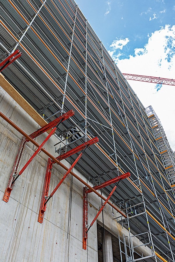 Metrisch kombinierbar: Tragfähige Konsolen auf Basis von VARIOKIT Kernbauteilen unterstützen das PERI UP Fassadengerüst dort, wo der Untergrund nicht genügend tragfähig ist oder darunter liegende Bereiche als Verkehrsfläche freizuhalten sind.