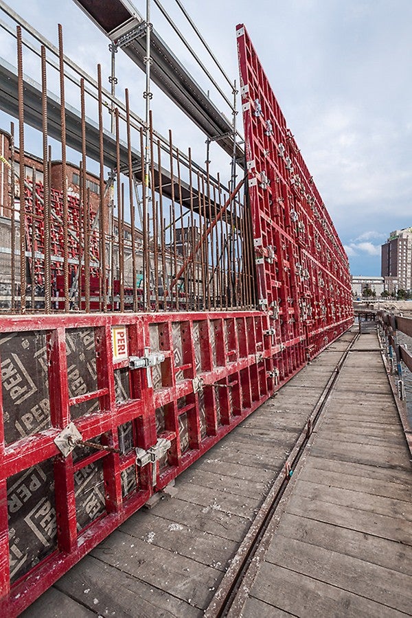 Für die Herstellung der Stützwand wurde die Sohlschalung einfach mit drei zusätzlichen, liegenden MAXIMO Elementen aufgestockt. Auf der Gegenseite diente ein PERI UP Bewehrungsgerüst als Arbeitsgerüst zum Bewehren sowie Schließen der Schalung.