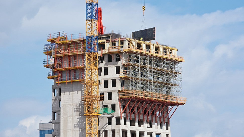 Podpěrné lešení PERI UP založené na lávkách VARIOKIT u východní fasády až do výšky jejího druhého zlomu.