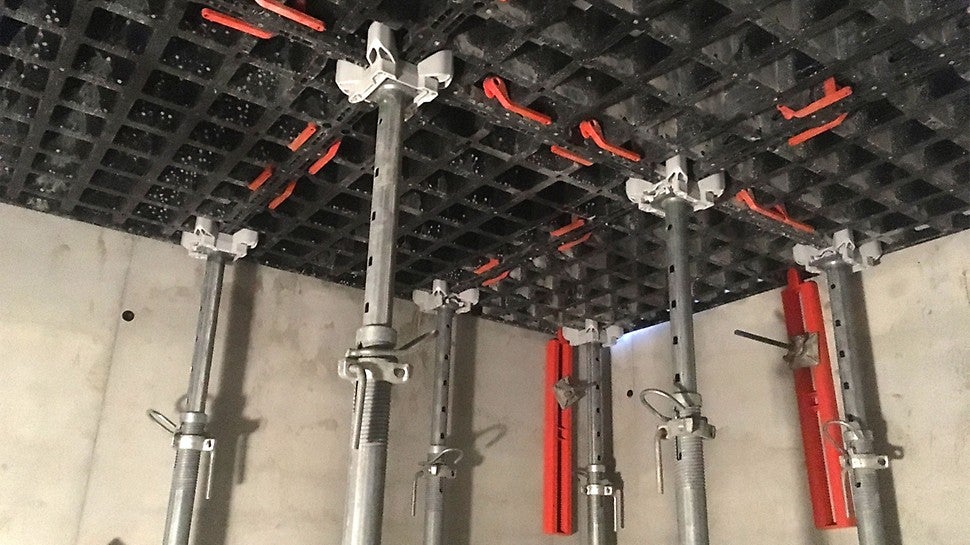 Punainen DUO-tukipalkki toimii jäykisteenä ankkuroiden holvimuotin kiinni seinään.