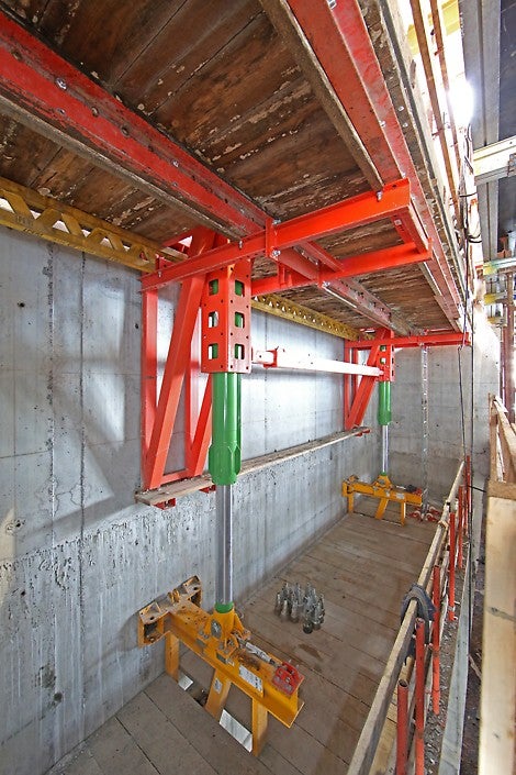 The green hydraulic cylinder pushes off of the yellow climbing bracket to advance the red working bracket – which carries the entire system, consisting of formwork and platforms – to the next level. The climbing bracket will later re-use the same anchor points as the working bracket, resulting in significant time savings.