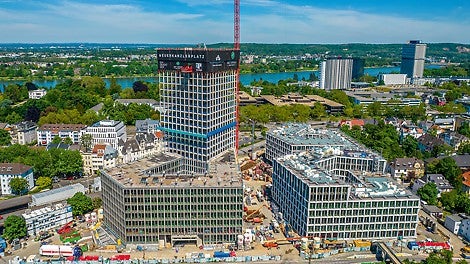 Der Neue Kanzlerplatz mit drei pentagonalen Gebäuden und dem 101,50 m hohen Hochhausturm bietet 115.000 m² Nutzfläche im Herzen Bonns.<br/>(Foto: Art-Invest / KIRO, Markus Kirch)<br/><br/>