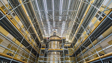 Um in dem Innenhof eine Arbeits- und Lagerplattform in 10 m Höhe nutzen zu können, wurde eine Gerüstüberbrückung erstellt – alles aus Teilen des Gerüstbaukastens, ausschließlich mit Diagonalabhängungen und bis auf die Verankerung an den Wänden komplett kupplungsfrei ausgeführt.