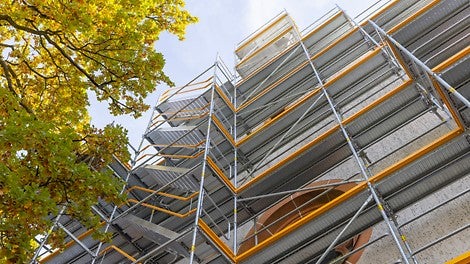 Die Treppe in 67 cm Breite passt sich dank des Gerüstknotens am Easy Stiel nahtlos an das PERI UP Fassadengerüst an. 