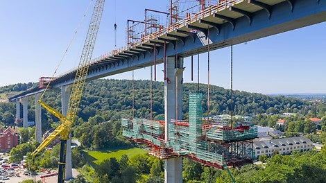 Die fünf höchsten Brückenpfeiler erhalten seitlich angefügte Stahlbetonvouten, die in den Stahlhohlkasten einbinden. Die über 50 m lange Voutenschalung wird inklusive der Bewehrung mittels hydraulischer Lochstangenheber nach oben gezogen.<br/>