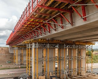 Tämä VARIOKIT-järjestelmäosilla toteutettu tukiratkaisu takaa turvalliset kuormien siirrot ulokkeita rakennettaessa.<br/>