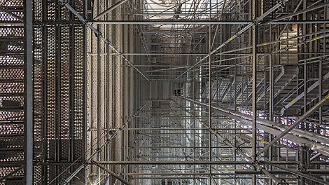 Der Zugang und der vertikale Materialtransport erfolgen über einen in die Gerüstkonstruktion integrierten Treppenturm sowie einen Bauaufzug.