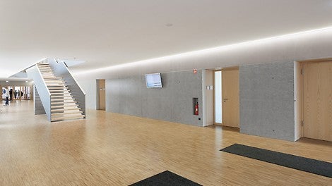 Die OSB Struktur der Sichtbetonwände unterstreicht die freundliche Architektur des neuen Berufsschulzentrums. Der erste Bauabschnitt wurde bereits 2013 fertiggestellt und bezogen.