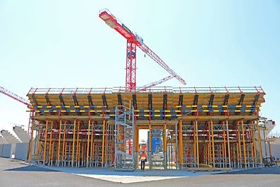 Deux ailes convergent au-dessus de l&#039;entrée pour former un voile continu.