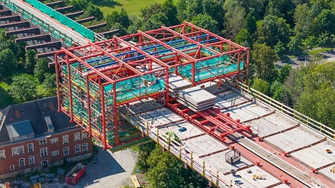 Die modulare Stahlverbundbauweise erfordert das Verlegen von Halbfertigteilen auf die Stahlquerträger in luftiger Höhe.<br/>