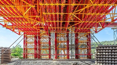 Sigurno podupiranje oplate glavnog nosača mostovske konstrukcije i prenos velikog opterećenja sveže betonske mase na tornjeve teške skele, formirane od standardnih elemenata ALPHAKIT sistema.