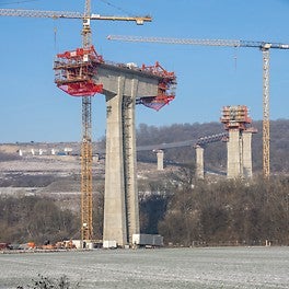 Während am nördlichen Doppelpfeiler noch der Hammerkopf eingeschalt ist, werden vom südlichen Hammerkopf aus bereits die ersten Überbauabschnitte im Freivorbau hergestellt.