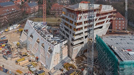Studierendenzentrum (links), Forschungszentrum (Mitte) und Auditorium (rechts) definieren das neue, außergewöhnliche Zentralgebäude der Leuphana Universität der Hansestadt Lüneburg. Verdeckt dahinter entsteht die tragende Stahlbaukonstruktion des Seminarzentrums.