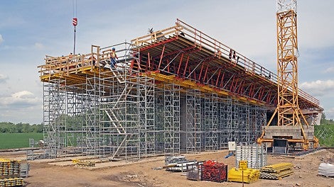 Bezpieczna praca i komunikacja na placu budowy z systemami deskowań i rusztowań PERI