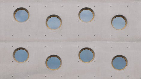 Regularly arranged circular windows and a defined joint and tie pattern in the wall area.