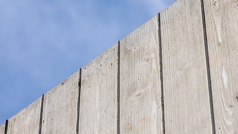 Mit einer sehenswerten, einer Brettstruktur nachempfundenen Betonoberfläche passt sich die Schutzwand an das Orts- und Landschaftsbild an.