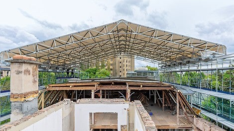 Das LGS 75 Wetterschutzdach auf Basis des PERI UP Gerüstbaukastens ist verfahrbar ausgebildet. So kann einerseits witterungsgeschützt gearbeitet werden, andererseits wird ein Materialtransport mittels Baustellenkran ermöglicht.