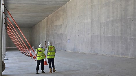 Internal view of resevoir walls. Neat high concrete finish of walls. Personnel show shear height of resevoir walls
