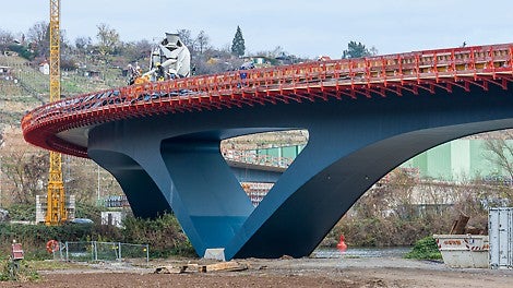 Die Ausführung als gevoutete Rahmenbrücke passt sich harmonisch an die von Weinbauhängen geprägte Landschaft an und ermöglicht zudem eine schlanke Konstruktion mit nur 1,90 m Bauhöhe in Feldmitte über dem Neckar.