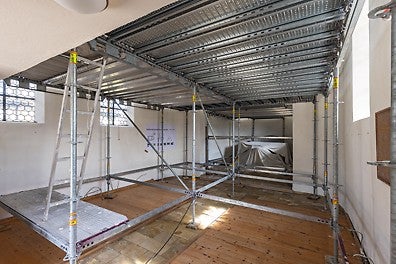 Im Innenraum schafft ein räumlich angepasstes PERI UP Gerüst eine sichere Arbeitsebene für die Arbeiten an der Deckenunterseite und an den Deckenmalereien.