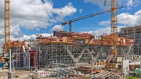 In direkter Nachbarschaft zum Flughafen München entsteht die neue AirportAcademy mit dem filigranen, aber tragenden Betonfachwerk in markanter Rollfeldoptik.