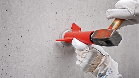 使用定位架均匀敲击混凝土堵头。