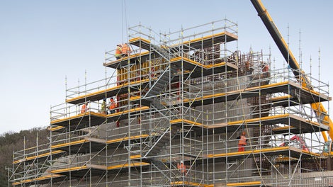 Working platforms and integrated access provides safety at height for construction workers using the PERI UP Rosett Flex Modular Scaffolding System