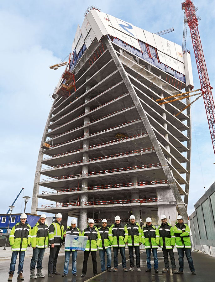 I responsabili del cantiere della Renaissance Construction posano orgogliosi davanti all’Evolution Tower, elegante grattacielo che si avvita su se stesso.