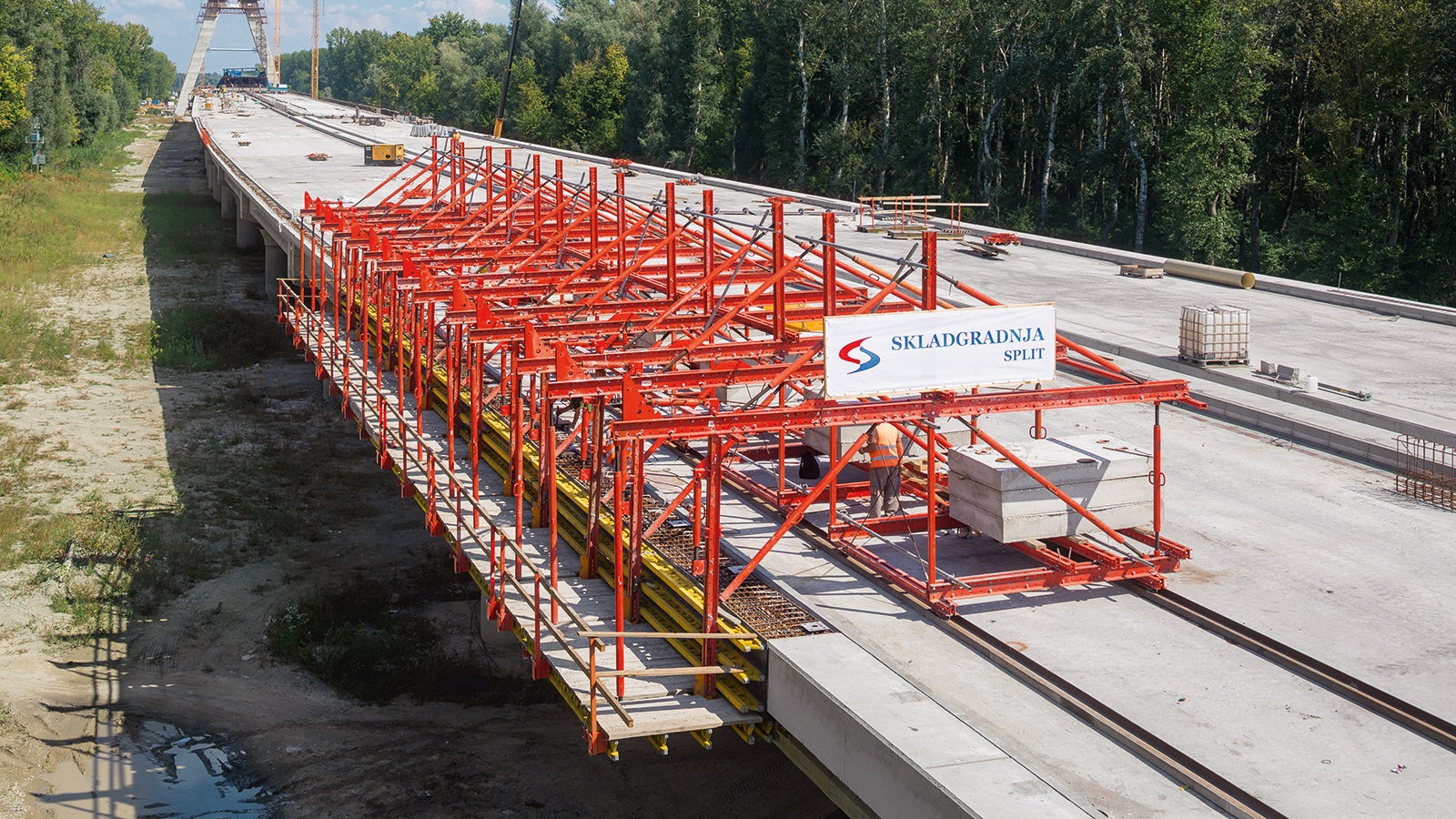 Auf dem Brückenüberbau verfahrbarer Wagen, der keine Verankerung im Bauwerk benötigt.