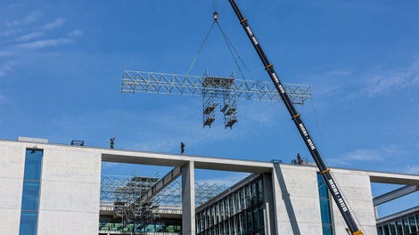 在地面预组装24米长、2.40米宽的PERI UP脚手架单元，使用移动式吊车吊装至屋顶，然后徒手向内移动。