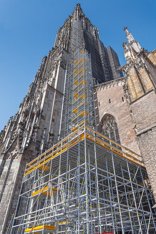 PERI UP schmiegt sich für die umfangreichen Sanierungsarbeiten bis auf 71 m Höhe an das Ulmer Münster an, eine Zwischenplattform in 7 m Höhe dient als Lagerungsmöglichkeit für die neuen Steine.
