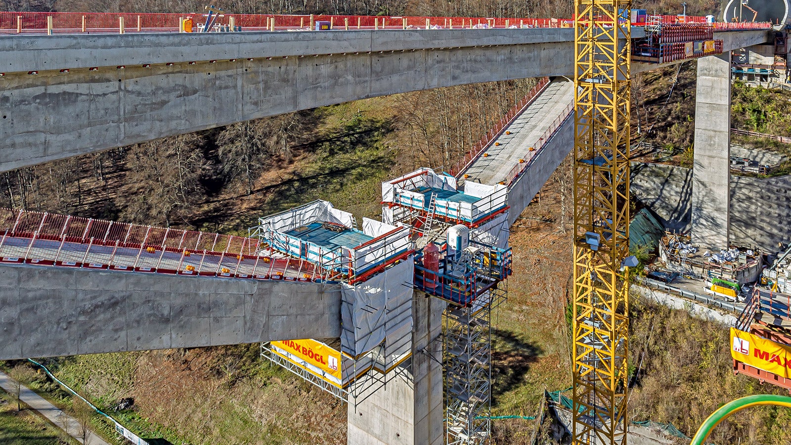 PERI Ingenieure konstruierten für die Bearbeitung der Schrägpfeiler einen schienengeführten Nachbehandlungswagen, indem sie das PERI UP Gerüstsystem mit VARIOKIT und der RCS Klettertechnik kombinierten.