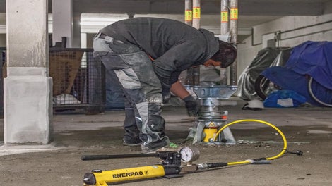 Mit nur einer Hydraulikeinheit ließen sich die PERI UP Schwerlaststützen vorspannen und – nach Erreichen der vollen Tragfähigkeit aller instand gesetzten Stahlbetonstützen – kontrolliert unter Last wieder absenken.