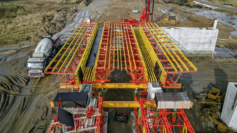 分别将模板与脚手架分别从一个桥梁转运至另外一个桥梁，为两个相互独立、双坡度、预应力T型板桥上部结构提供模板方案，先后浇筑两个混凝土上部结构。