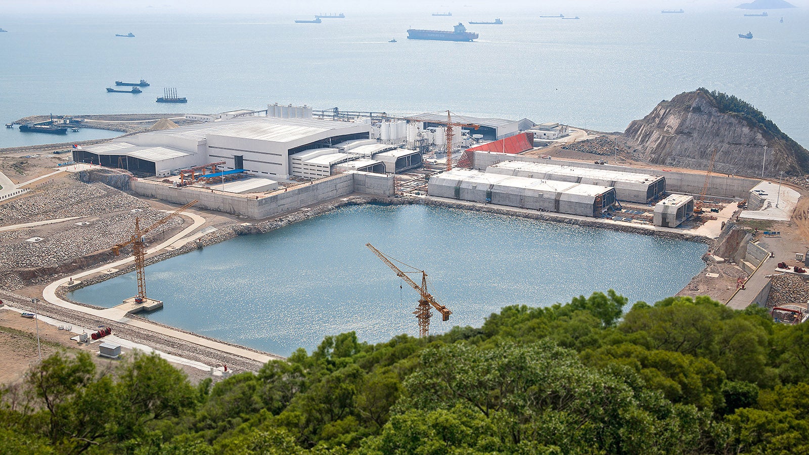 The finished tunnel tubes with lengths of 180 m are moved from the field factory into a dry dock, sealed with bulkheads and lowered gradually to reach sea level. Pontoons stabilize the tunnel sections during towing operations to the lowering point in the South China Sea.