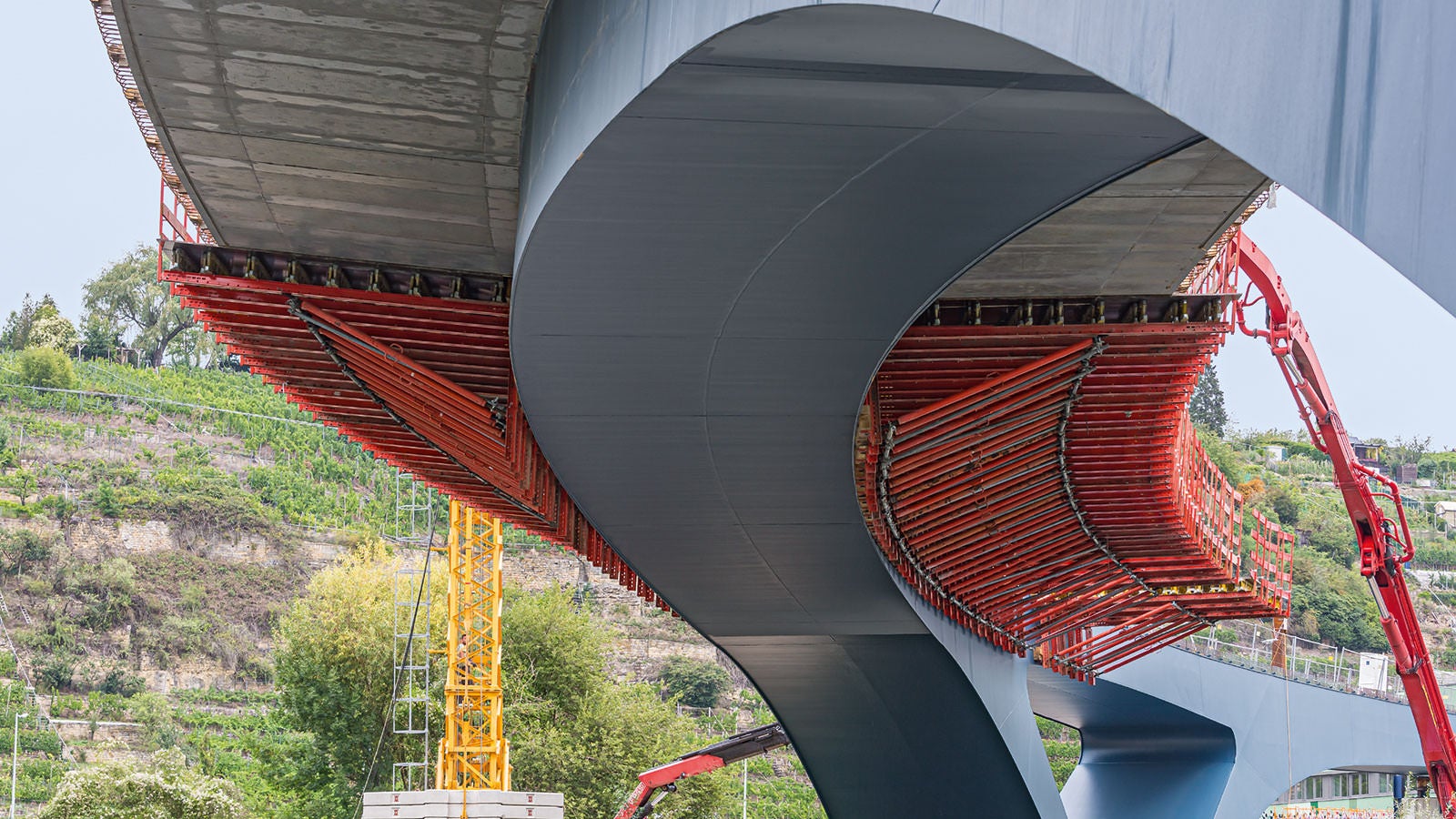 Der elegant geschwungene Brückenneubau über den Neckar ist als Stahlverbundbrücke mit schmalem Stahlgurt und weit auskragendem Betonüberbau ausgeführt.