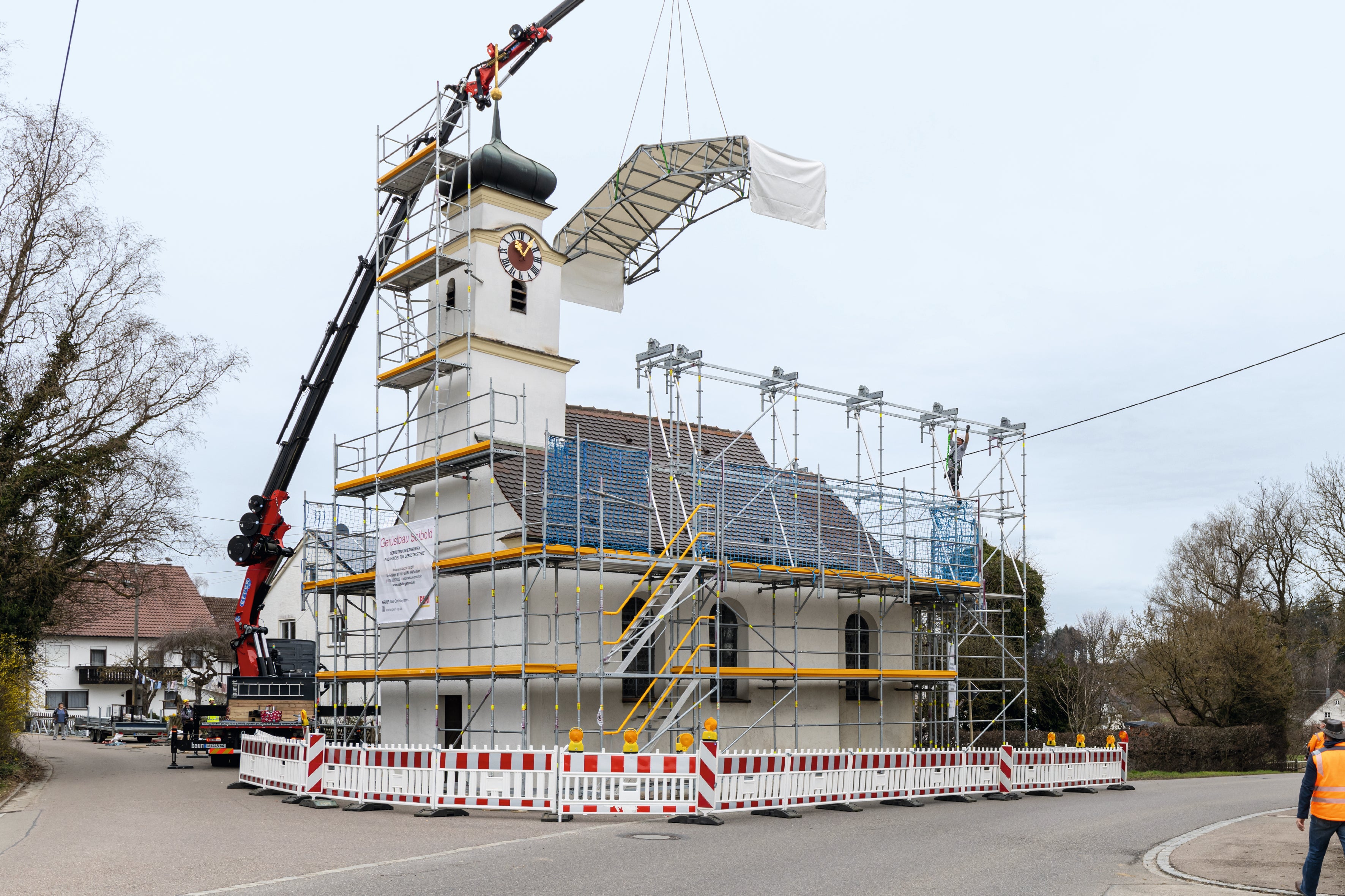 Das PERI UP Arbeits- und Schutzgerüst dient gleichzeitig als Stützkonstruktion für das Wetterschutzdach.