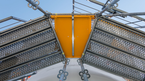 Сооружая леса вокруг цилиндрических резервуаров, зазор между клетками лесов может быть перекрыт добором настила. За счет скошенных краев и небольшой высоты элемента образуется плавный, безопасный переход. Сигнальный желтый цвет добора обращает внимание персонала на перепад высоты рабочей поверхности.<br/>