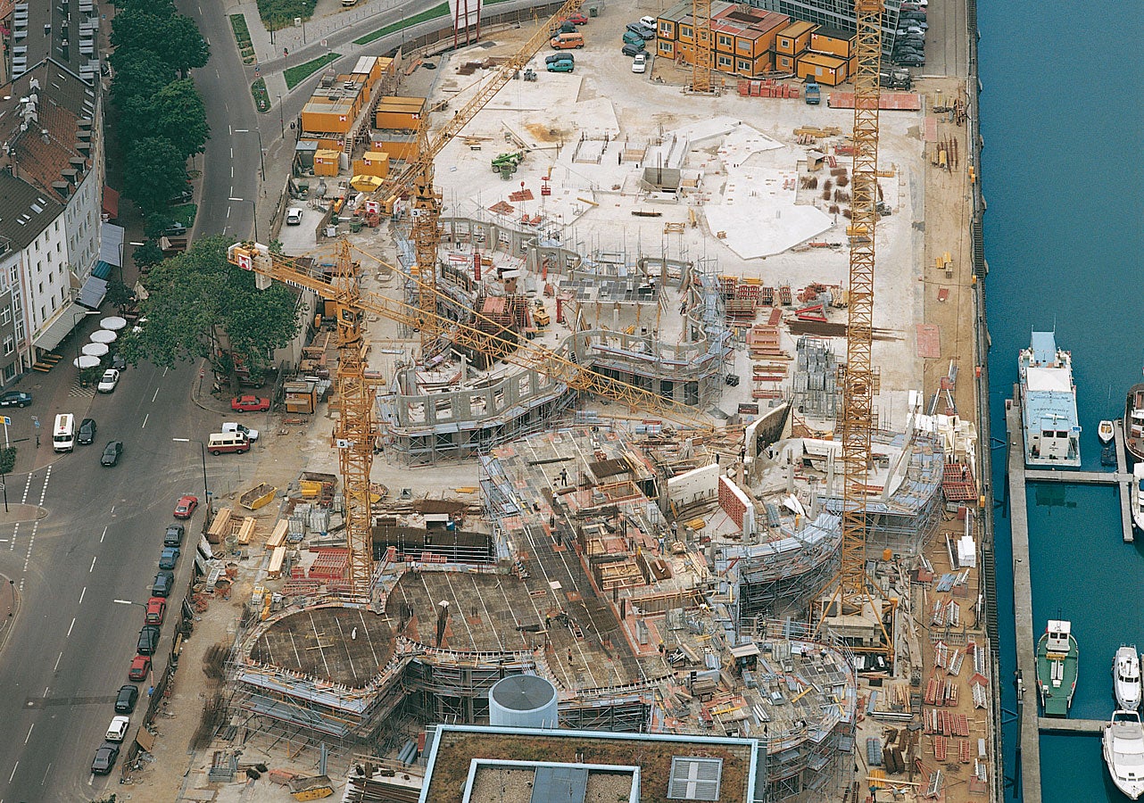 Os três edifícios espetaculares do novo complexo Zollhof em Dusseldorf durante diferentes fases de construção.